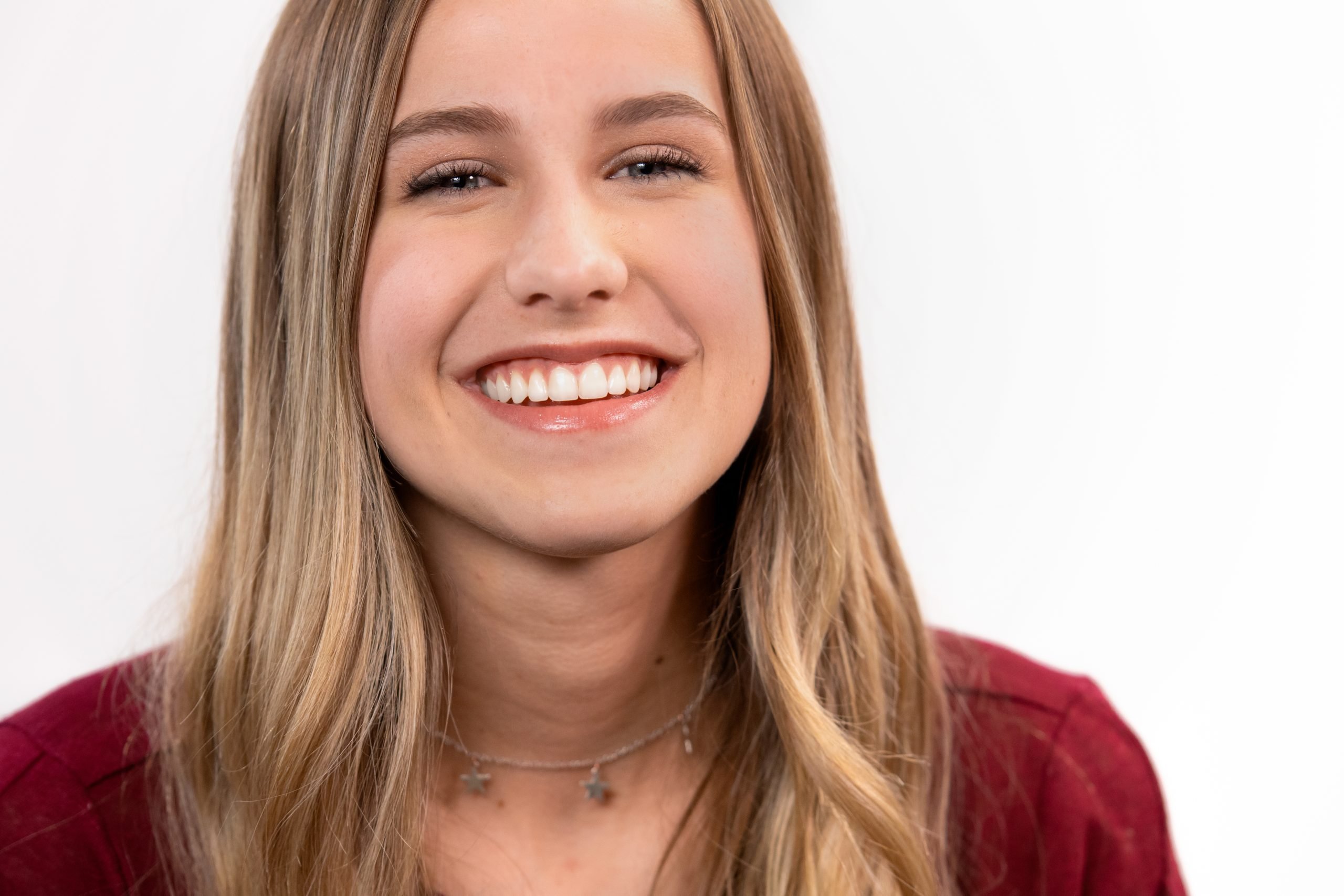 A woman with a red shirt is smiling