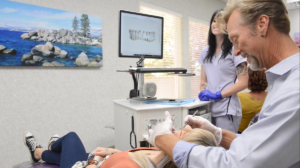 https://www.andrewsbraces.com/damon-braces/ Dr. Kevin is wearing gloves and examining a patient in the chair