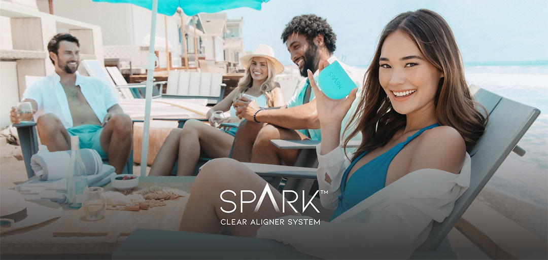 Four people smile at beach vacation with Spark Clear Aligner System